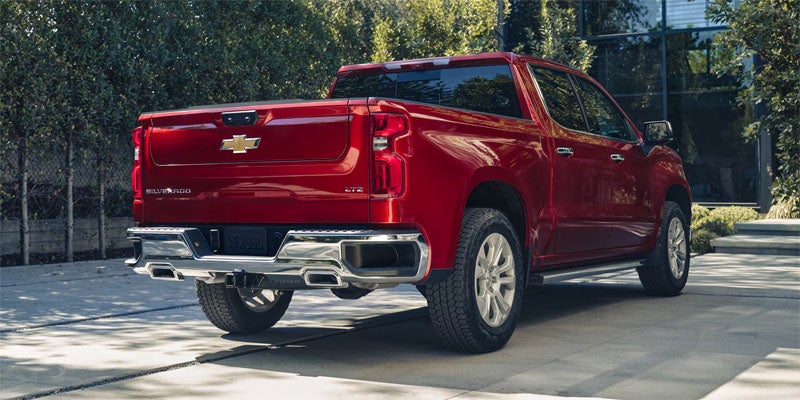 Rear view of a red Chevrolet Silverado showcasing its tailgate and distinctive taillights.